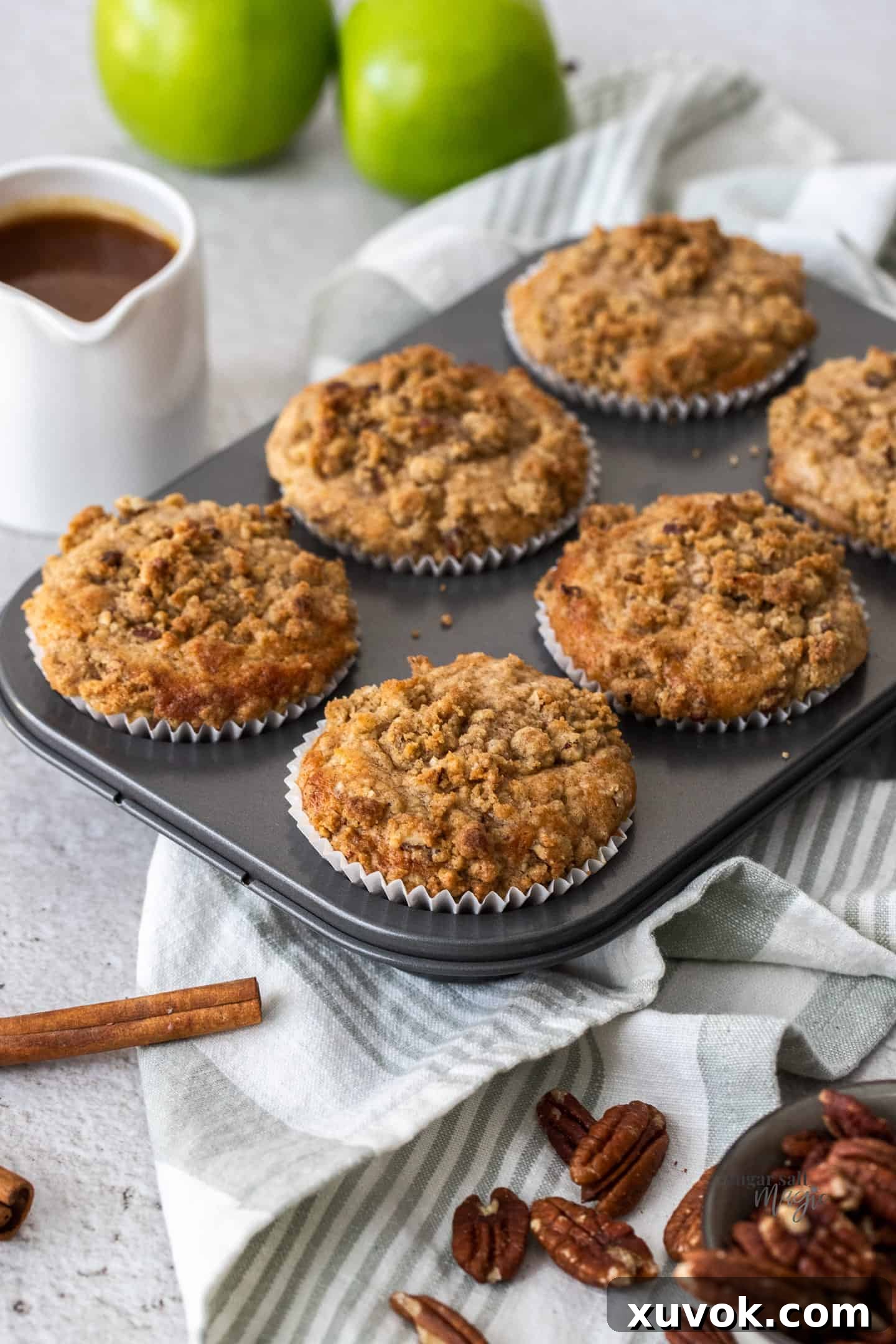 A muffin tin with 6 crumble-topped muffins in it, ready to be served or stored.