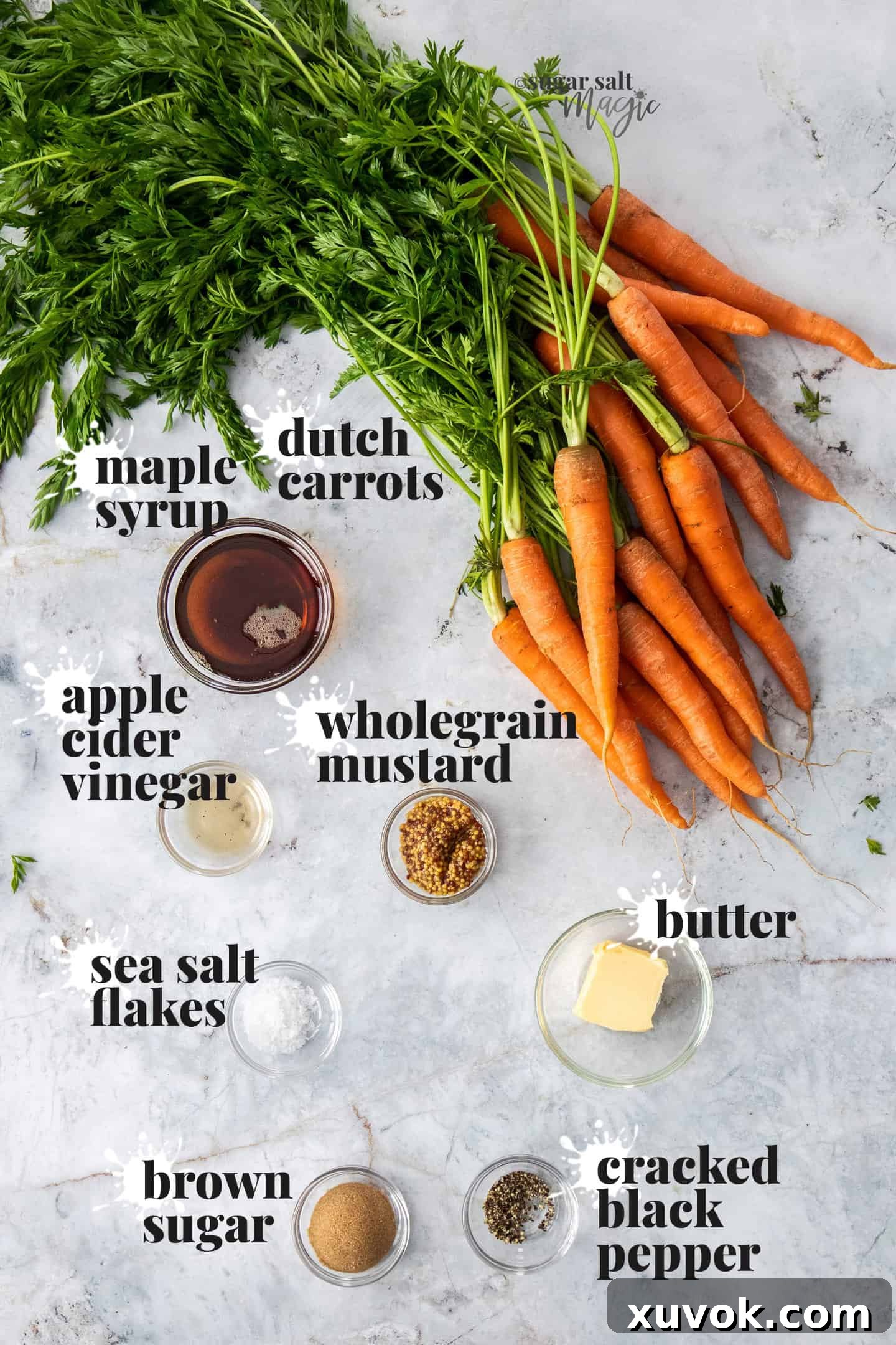Ingredients for maple roasted carrots on a grey marble benchtop.