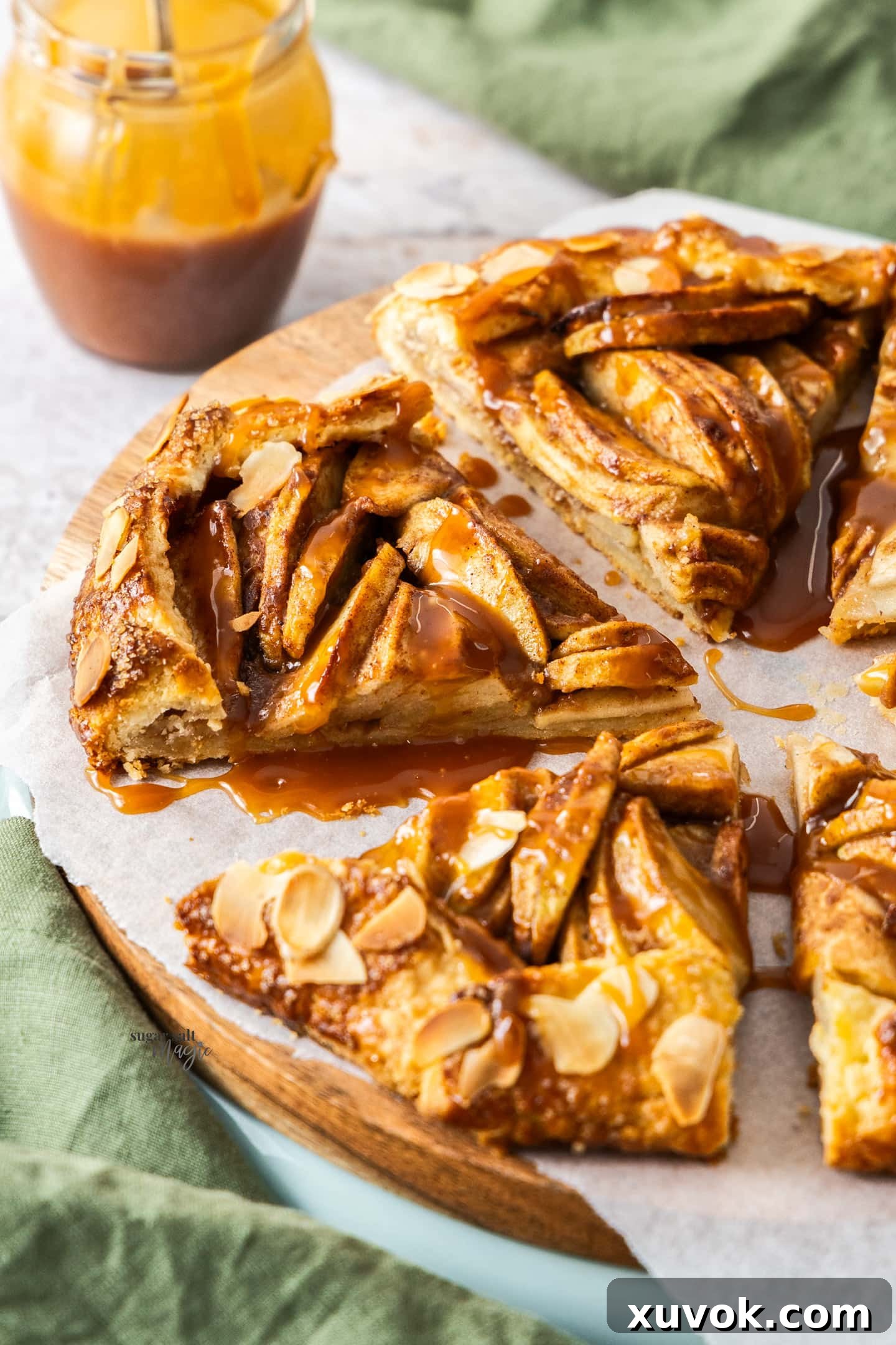 Slices of apple crostata neatly arranged on a wooden platter, showcasing its rustic perfection.
