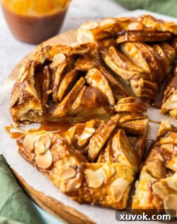 Closeup of a slice of apple crostata on a rustic plate, emphasizing its flaky crust and juicy filling.