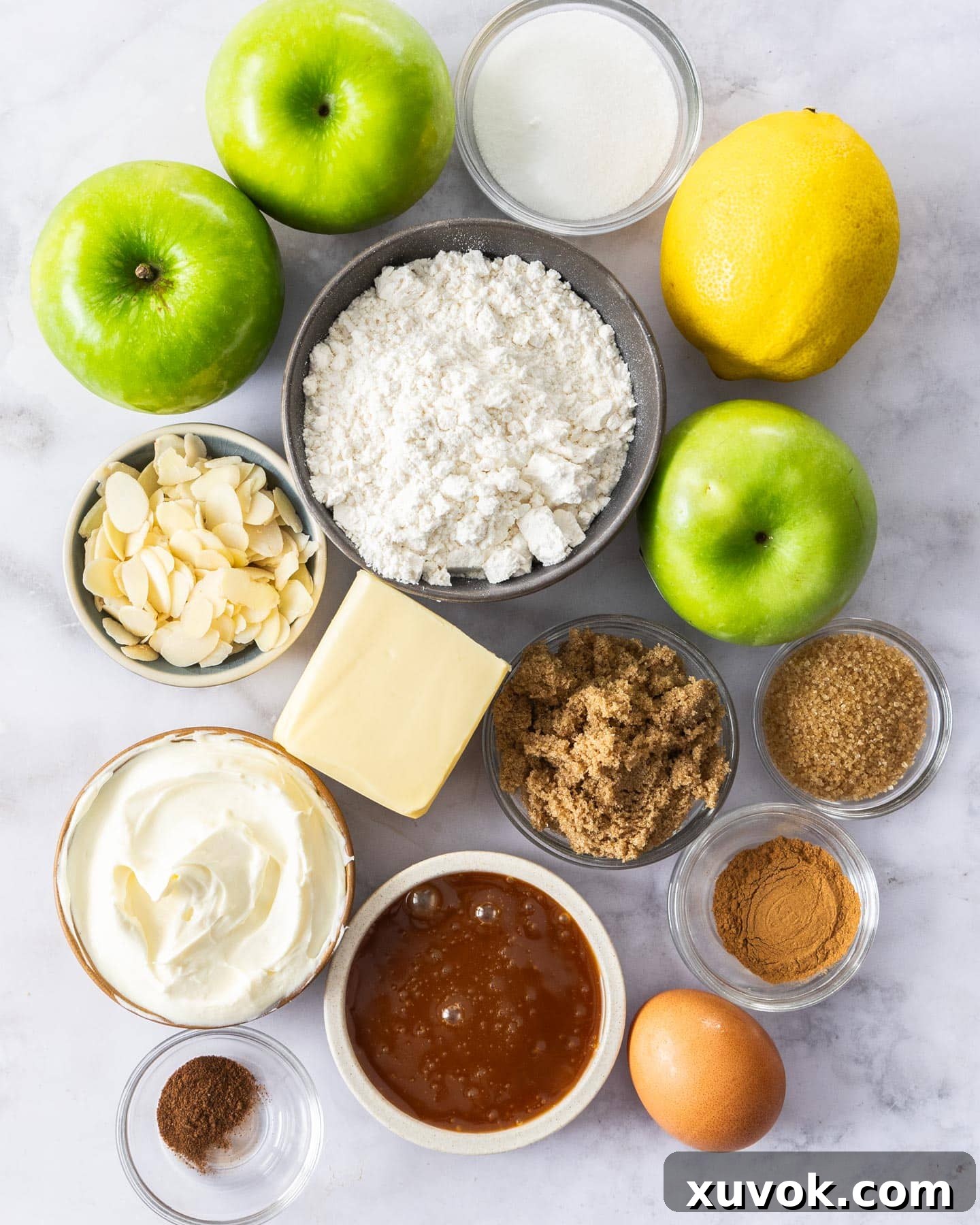 Ingredients for apple crostata laid out on a marble surface, ready for baking.