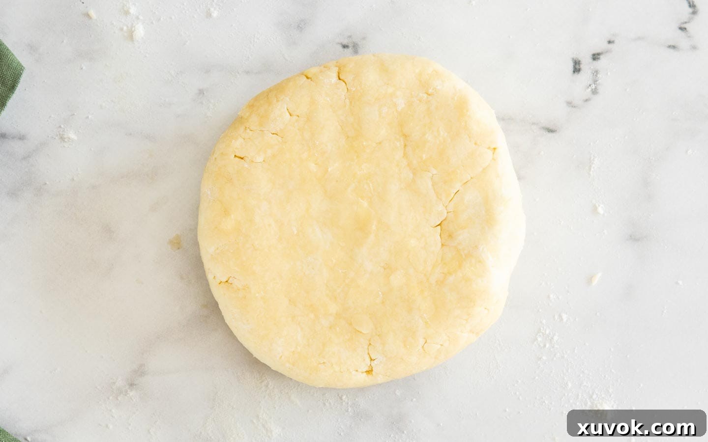 The pastry dough shaped into a disk and ready for chilling, a crucial step for flaky crust.