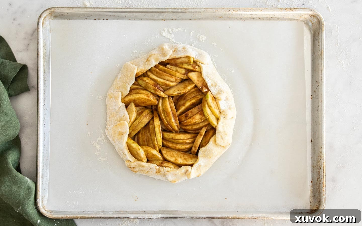 The dough edges carefully folded up around the apples, forming the rustic crostata shape.