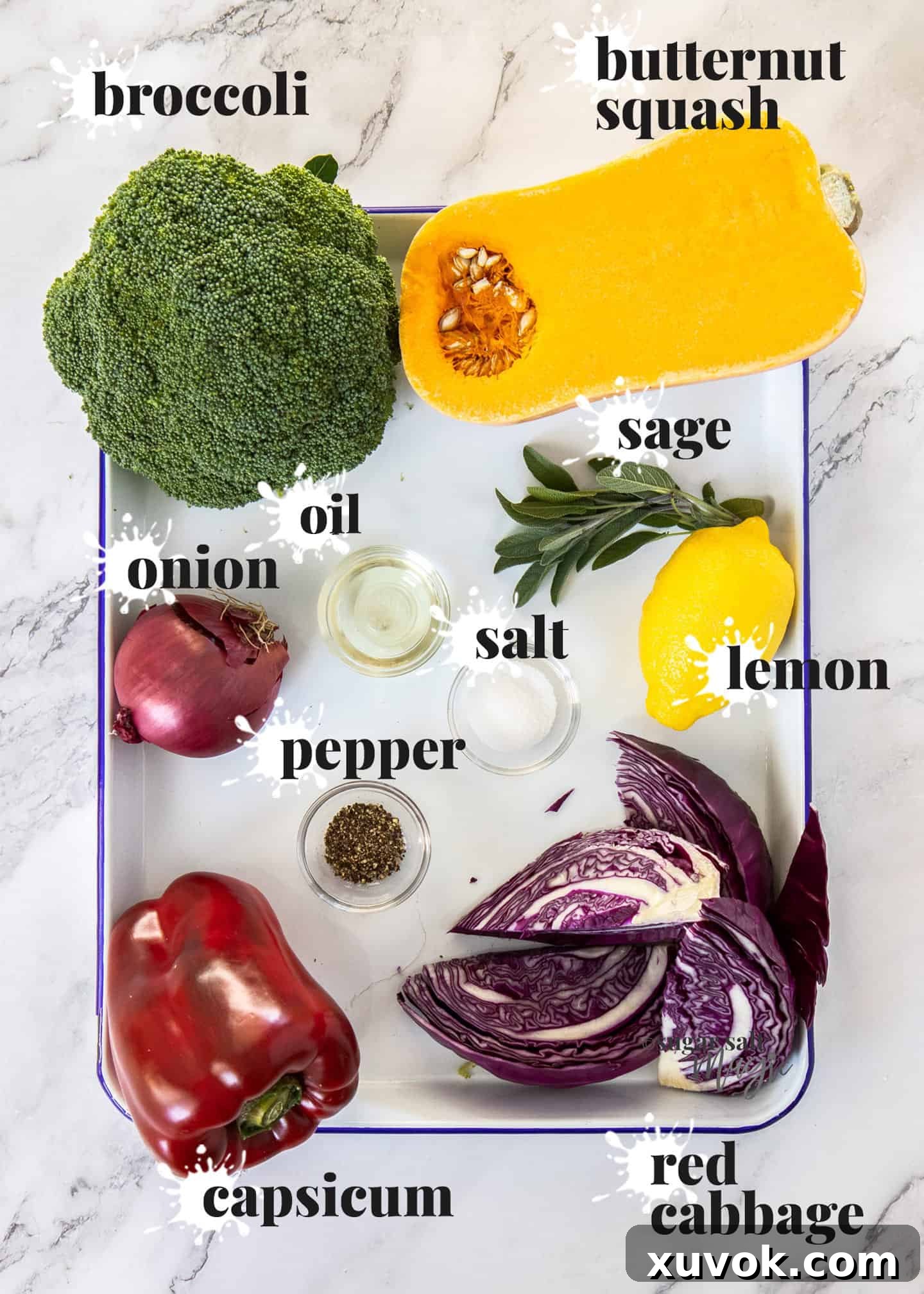 A vibrant assortment of raw vegetables, prepped and ready for roasting on a sheet pan.