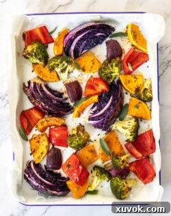 Top down view of a sheet pan filled with colourful roasted vegetables.