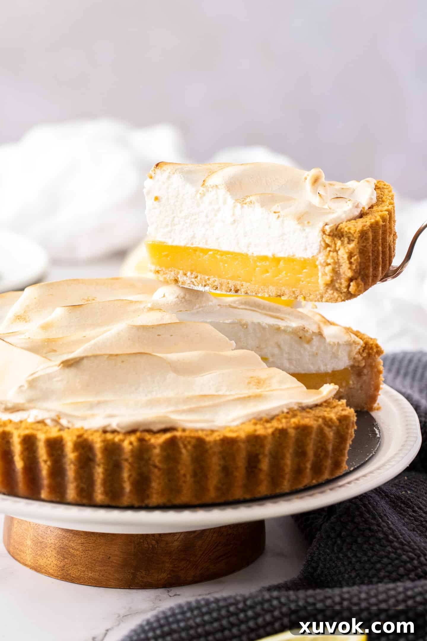 A slice of lemon meringue pie being lifted gracefully from the rest of the pie, showcasing its perfect layers.