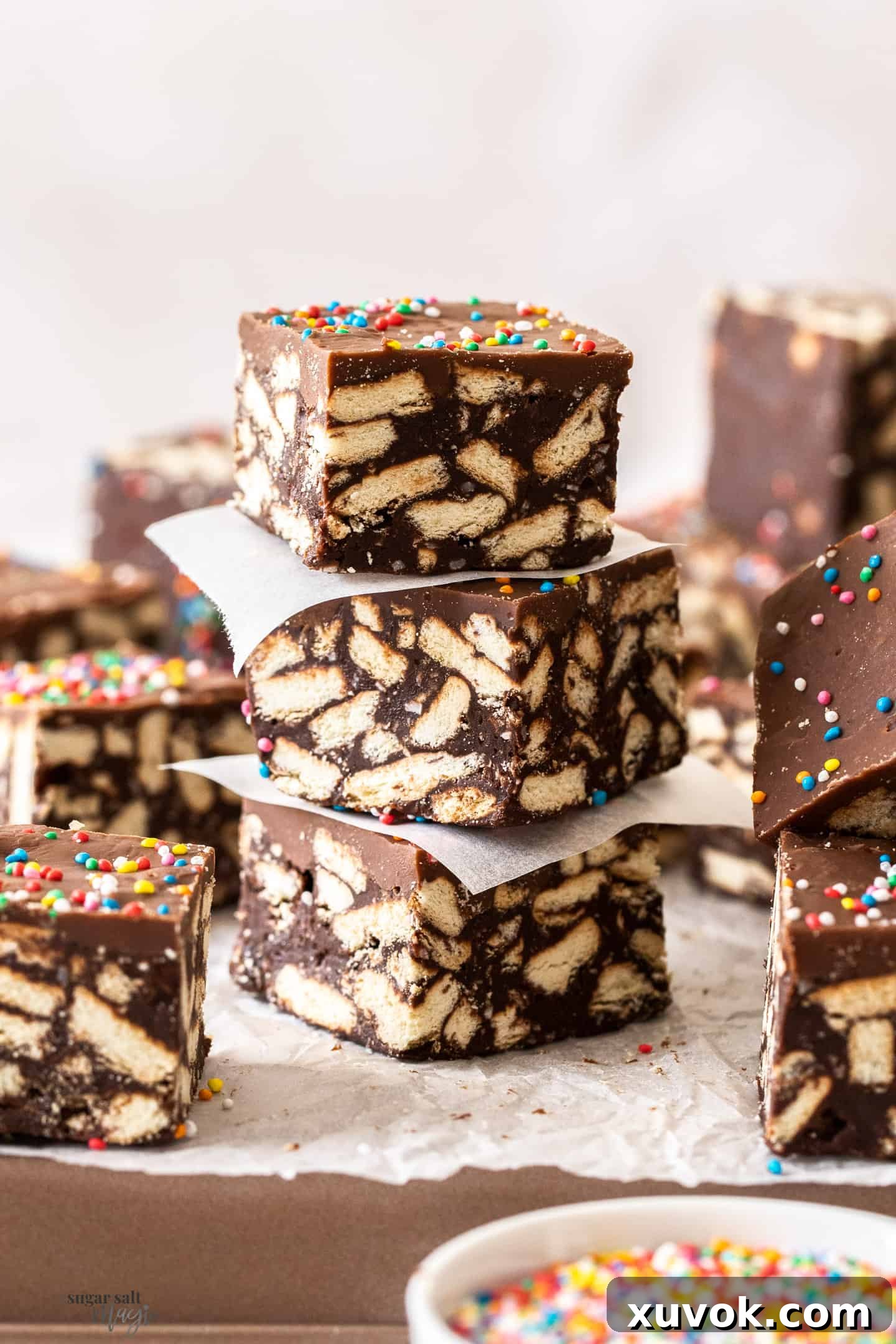 A stack of 3 pieces of hedgehog slice. A rich, chocolatey square with visible biscuit pieces and a smooth chocolate topping, ready to eat.