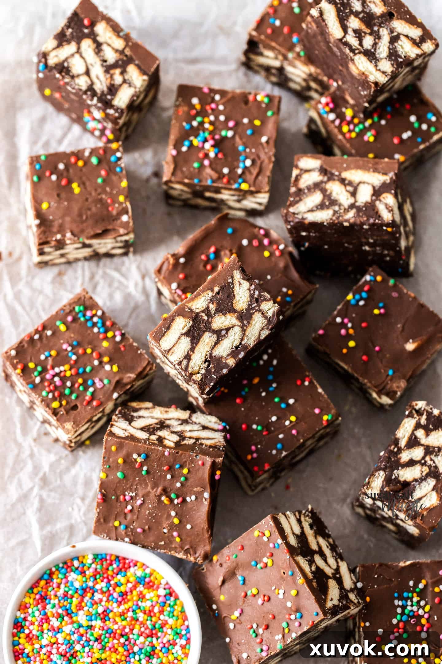 A batch of perfectly sliced chocolate hedgehog slice squares arranged neatly on a sheet of baking paper, showcasing their rich texture.
