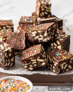 A pile of squares of hedgehog slice on a baking tin, highlighting the rich chocolate and biscuit texture.