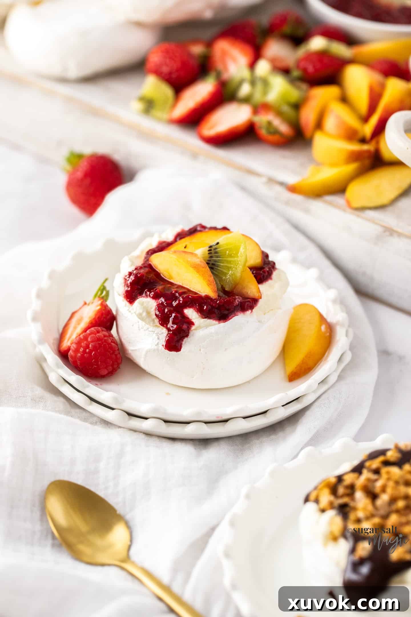 A single mini pavlova artfully topped with fresh berries and cream, presented on a small dessert plate.