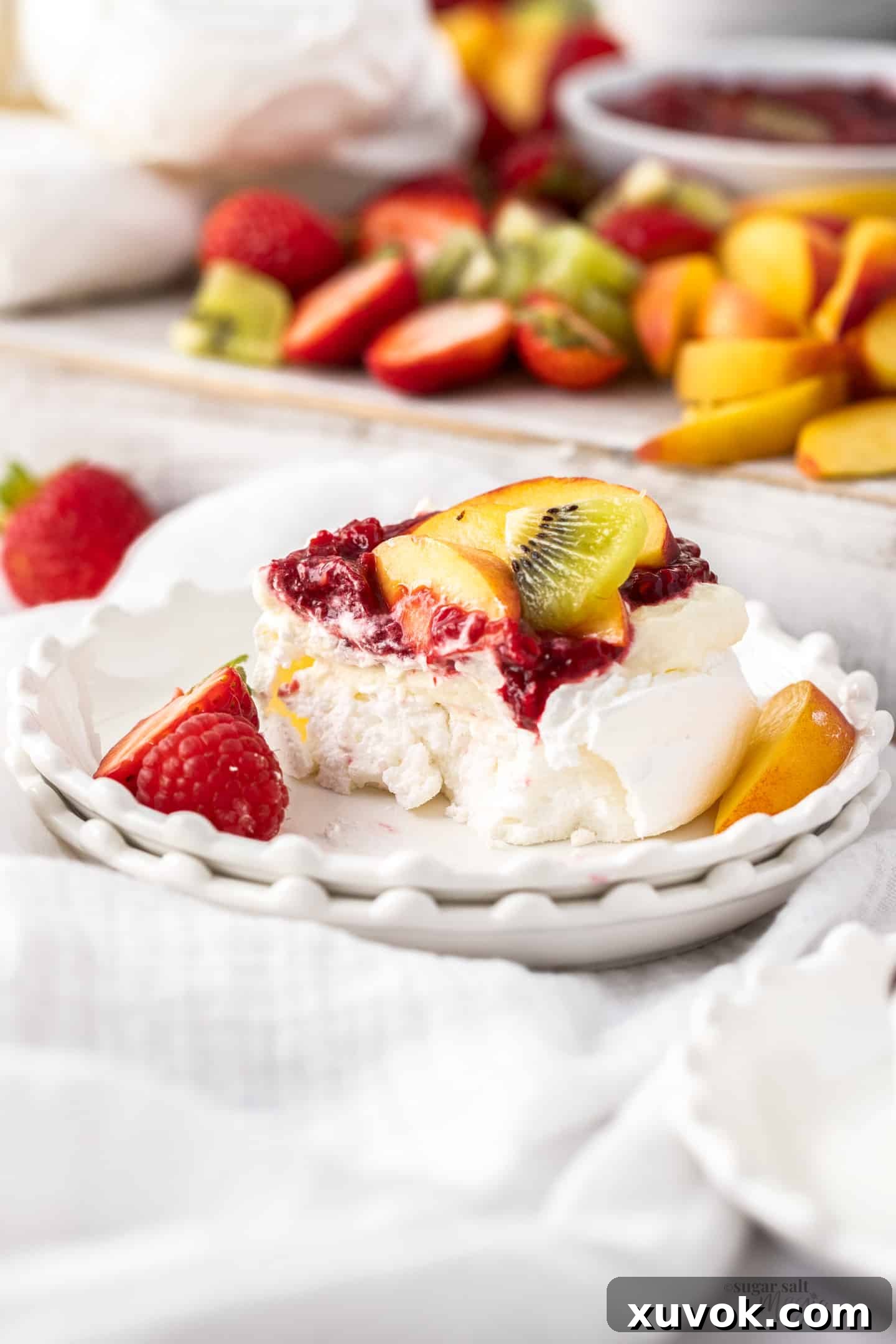 A mini pavlova expertly cut open, revealing its characteristic fluffy, marshmallowy interior and crisp outer shell.