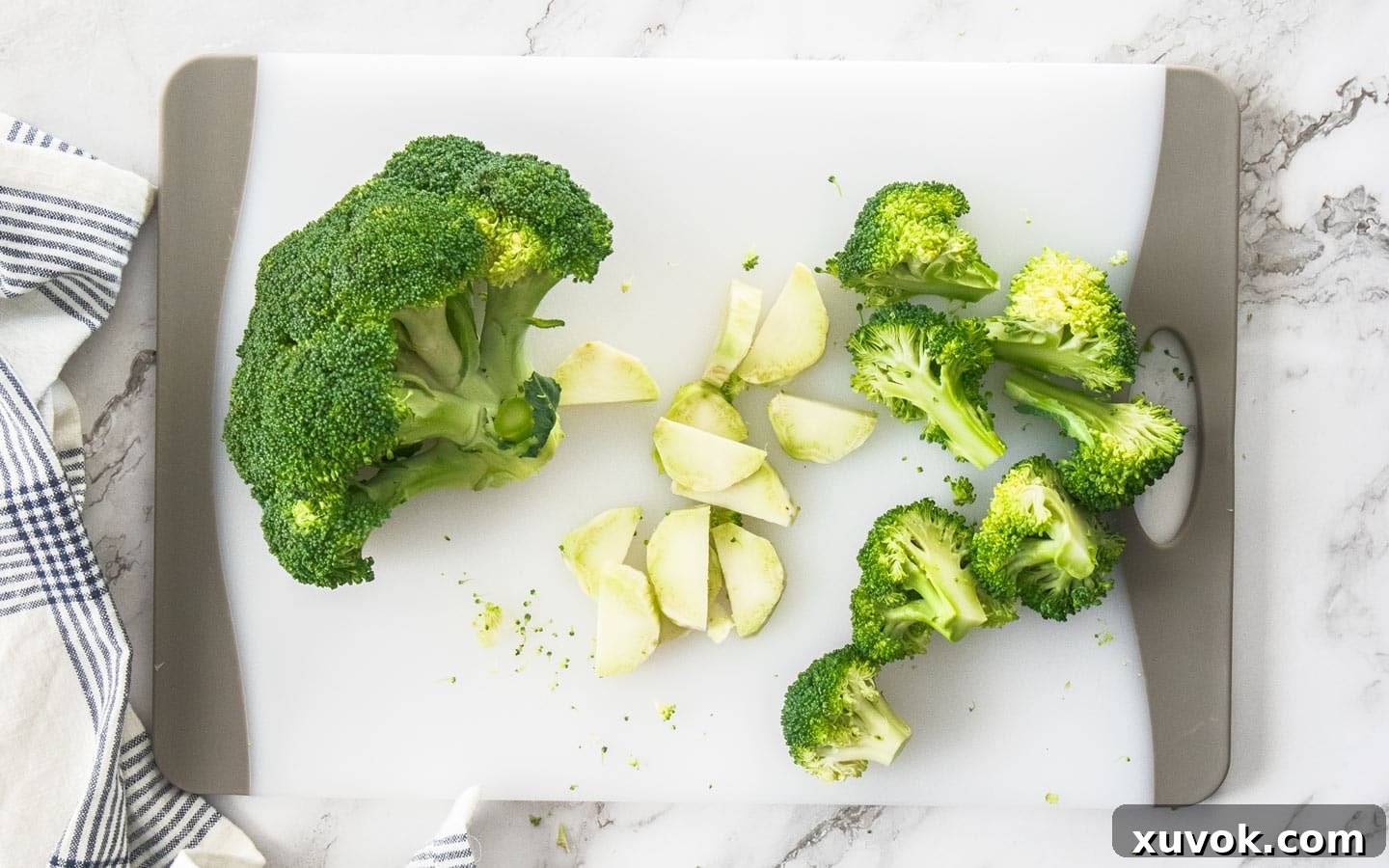 Broccoli pieces on a chopping board.