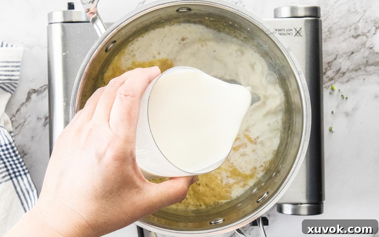 Adding milk to the saucepan.