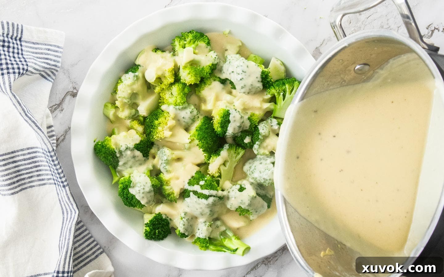 Pouring the sauce over broccoli in a dish.