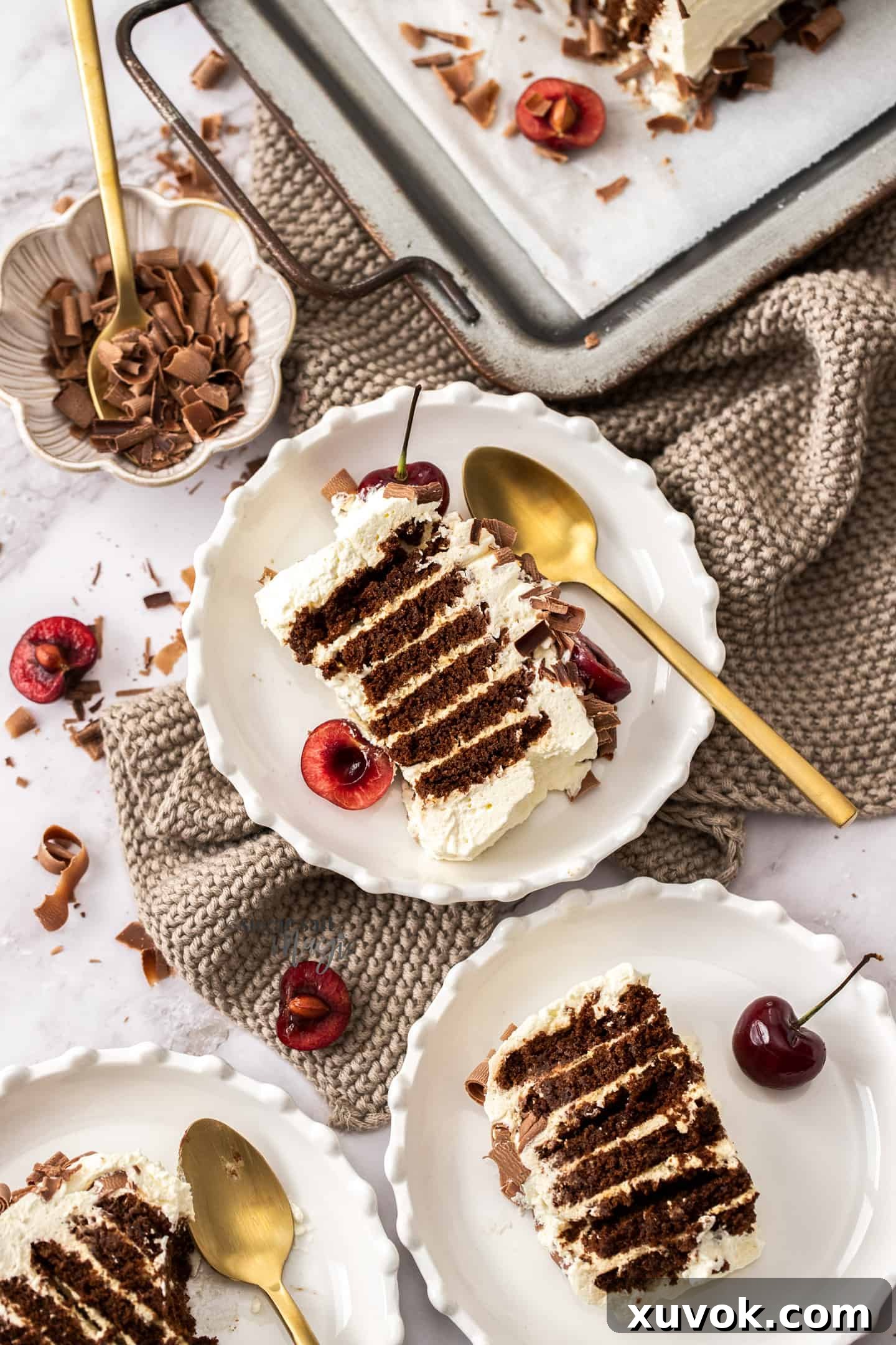 Two generous slices of chocolate ripple cake, garnished with chocolate curls and cherries, served on small dessert plates, ready to be enjoyed.