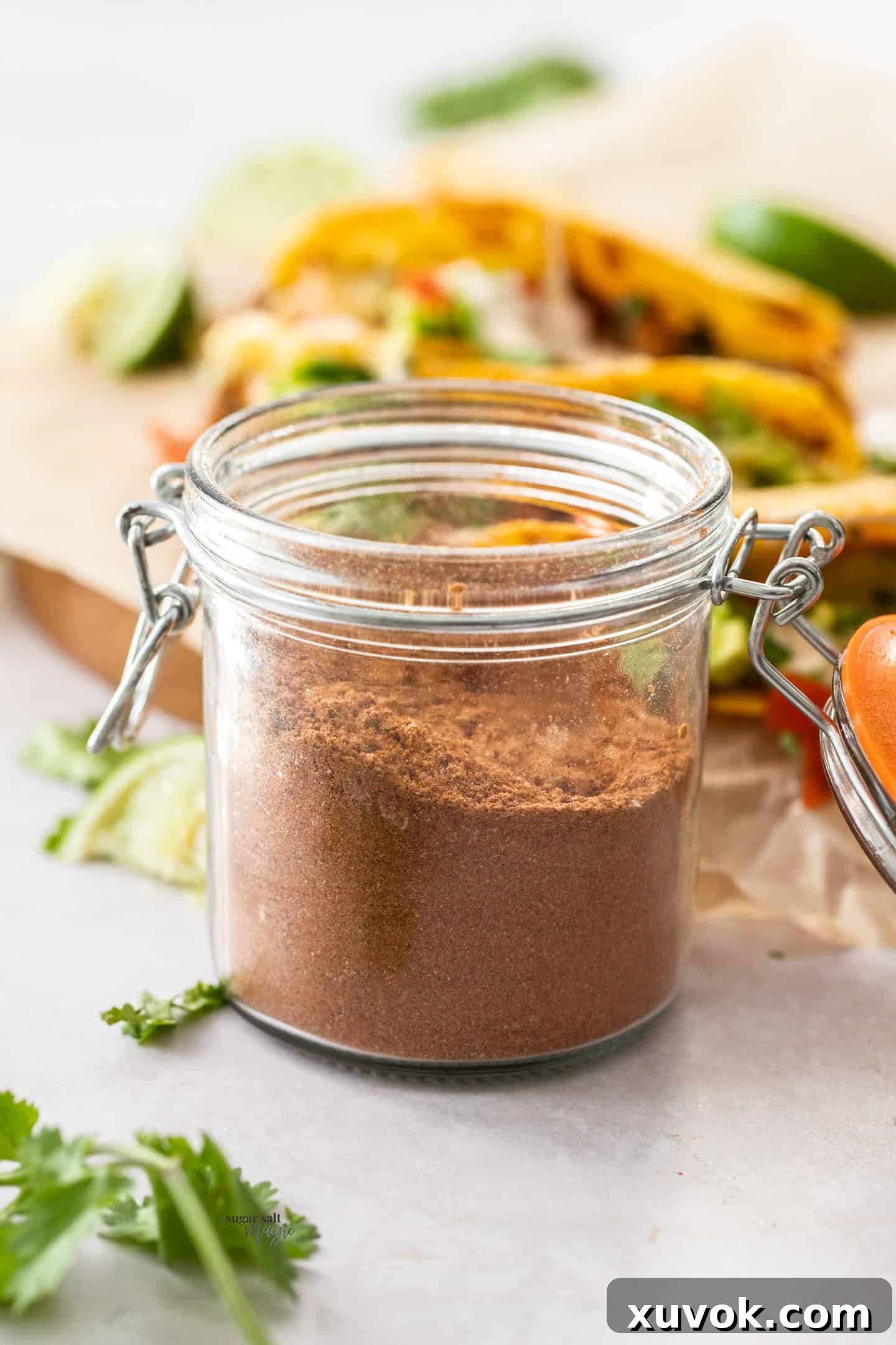 A small glass jar filled with vibrant, homemade taco seasoning, ready to be used.