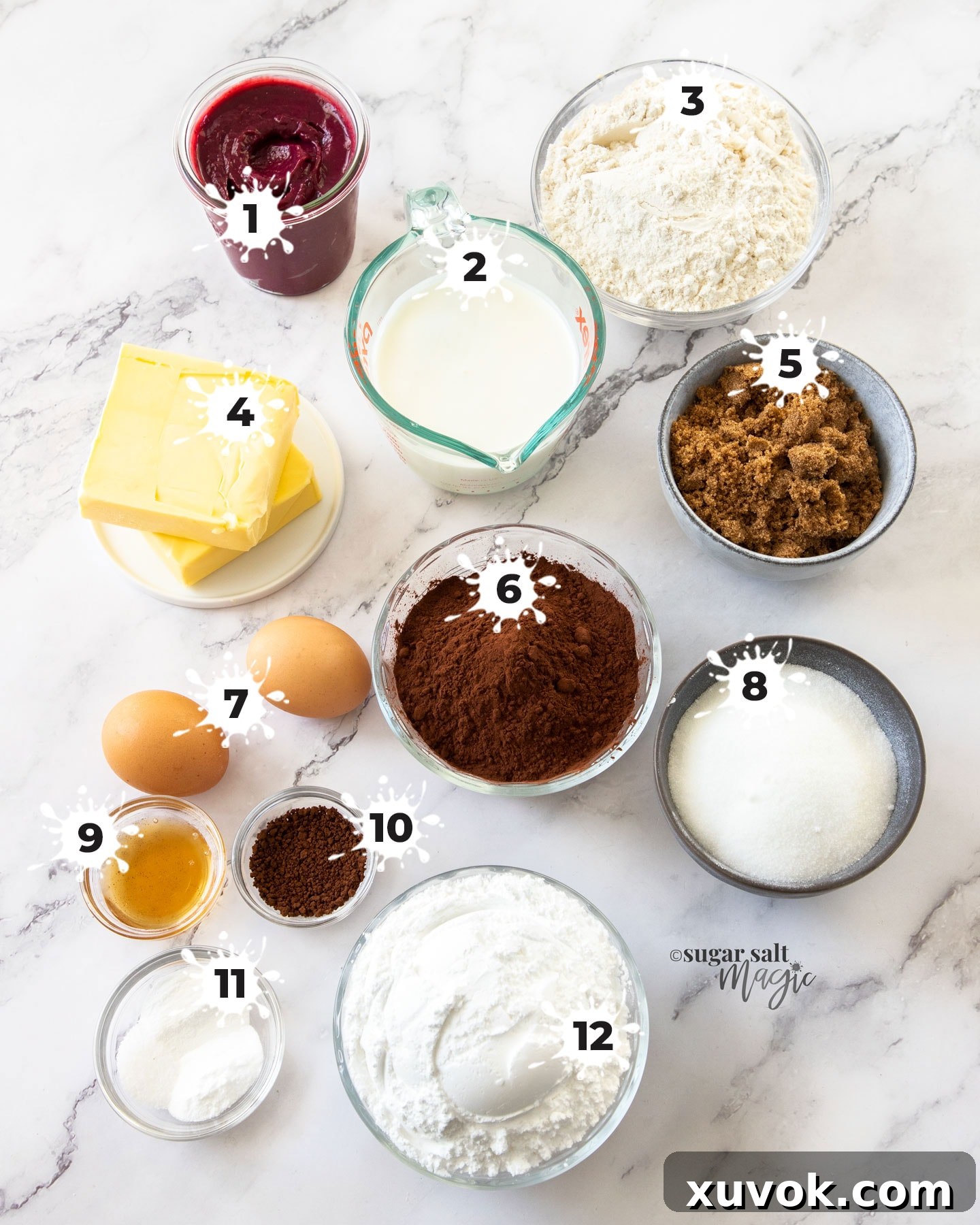 A beautifully arranged collection of fresh ingredients for baking a blackberry chocolate cake, displayed on a elegant marble surface.