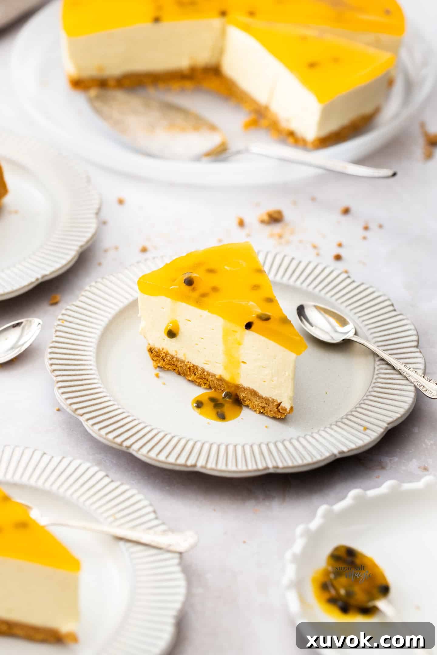A slice of passionfruit cheesecake on a small dessert plate, showing its creamy filling, golden crust, and vibrant jelly topping with seeds.