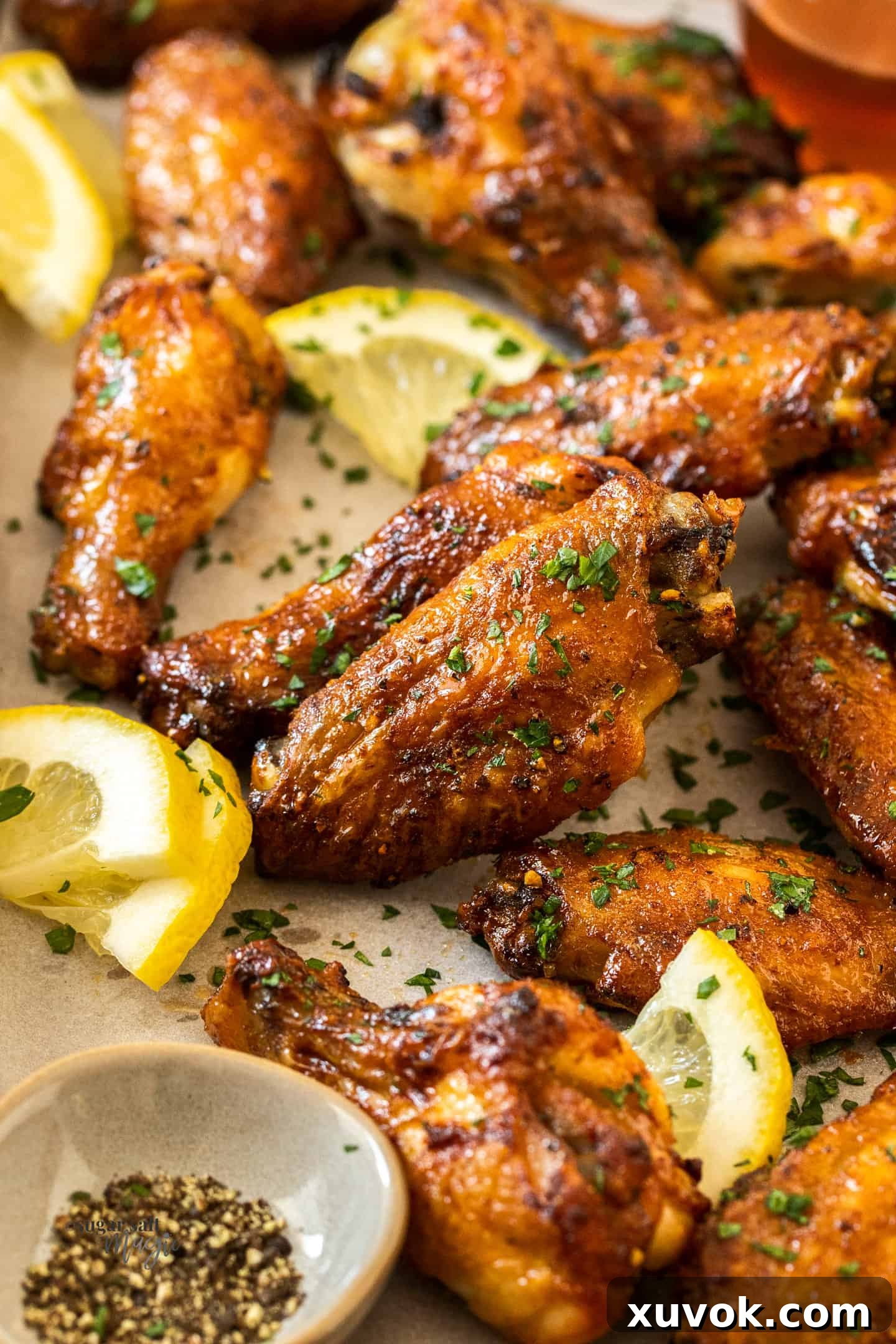 Close up of baked golden honey lemon pepper chicken wings, perfectly crispy and glistening with sauce.