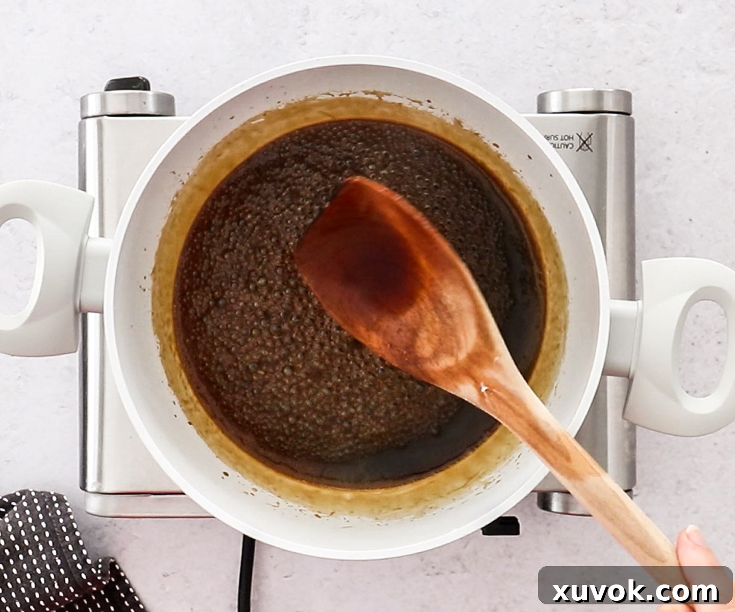 The teriyaki sauce has thickened to a perfect glaze consistency in the saucepan, now cooling to prepare for coating the salmon.