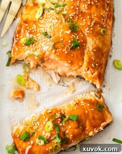 Top down view of the oven baked teriyaki glazed salmon broken into two pieces on a baking tray.