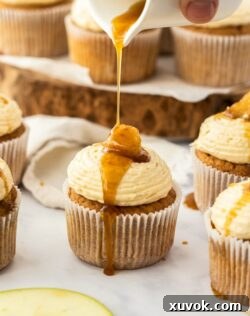 Syrup being drizzled over a cupcake with maple buttercream.