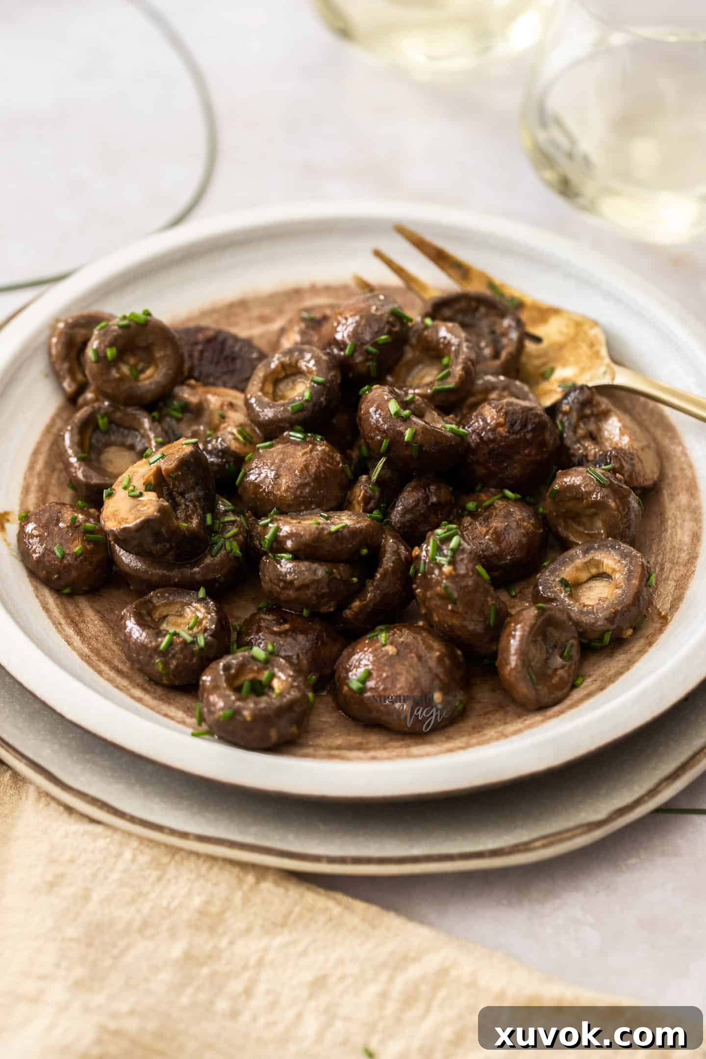 A white plate generously filled with golden-brown roasted miso mushrooms, with a elegant gold fork resting nearby.