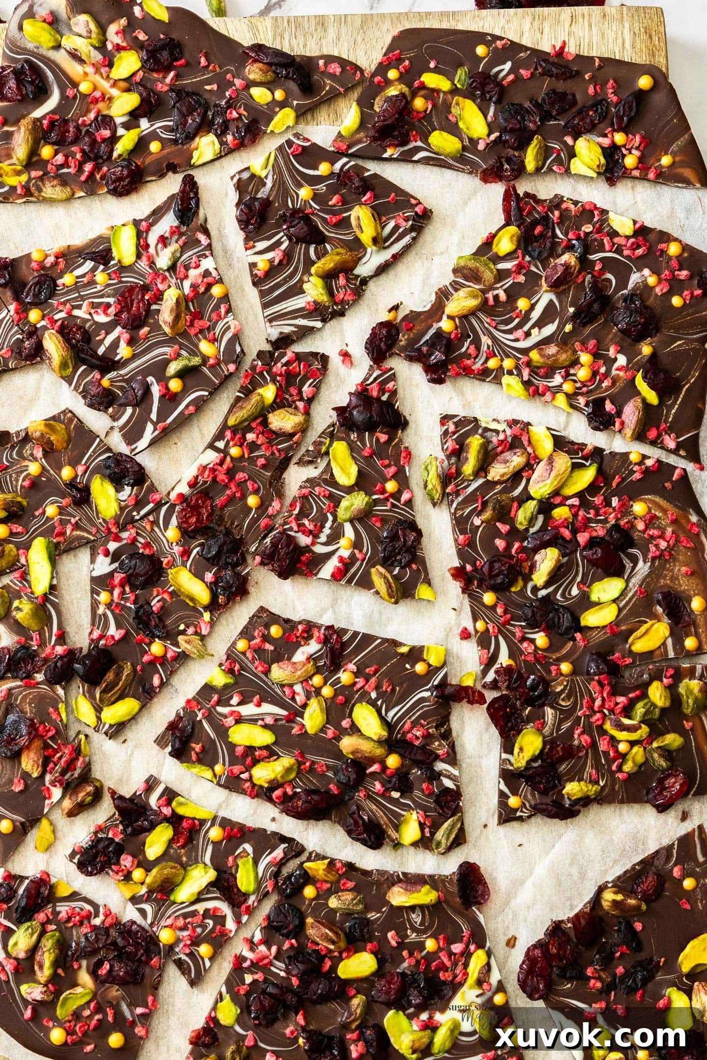 Top down view of Christmas chocolate bark broken into shards, showcasing a blend of dark and white chocolate with various festive toppings.