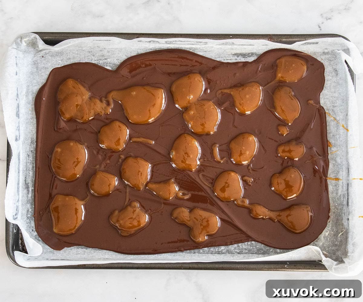Caramel dotted strategically over the bottom chocolate layer, preparing for the next step.