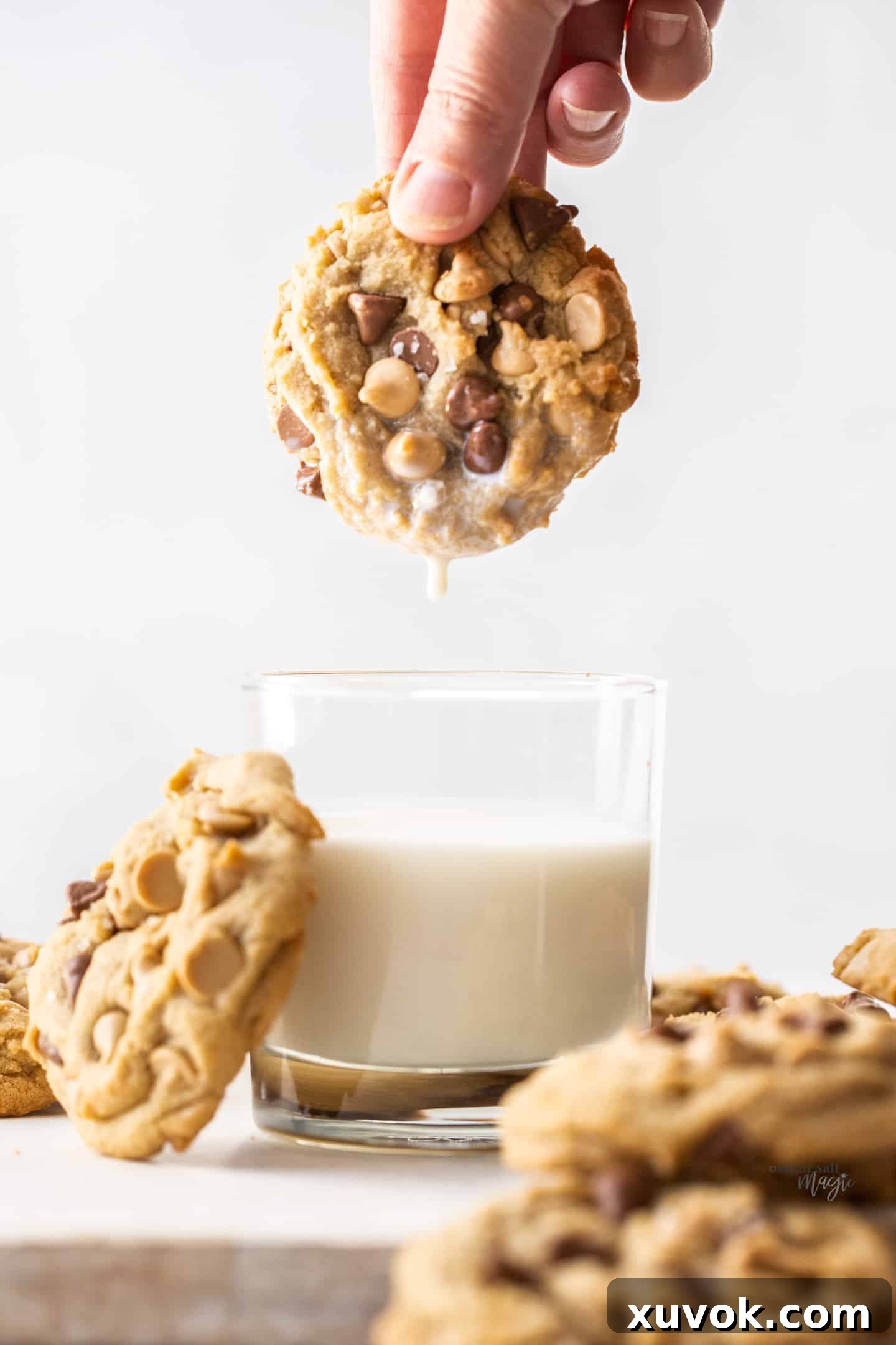 A Caramilk cookie gracefully dunked into a refreshing glass of milk, a classic pairing.