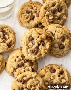 Top down view of a batch of caramilk cookies, perfectly golden and studded with chocolate.