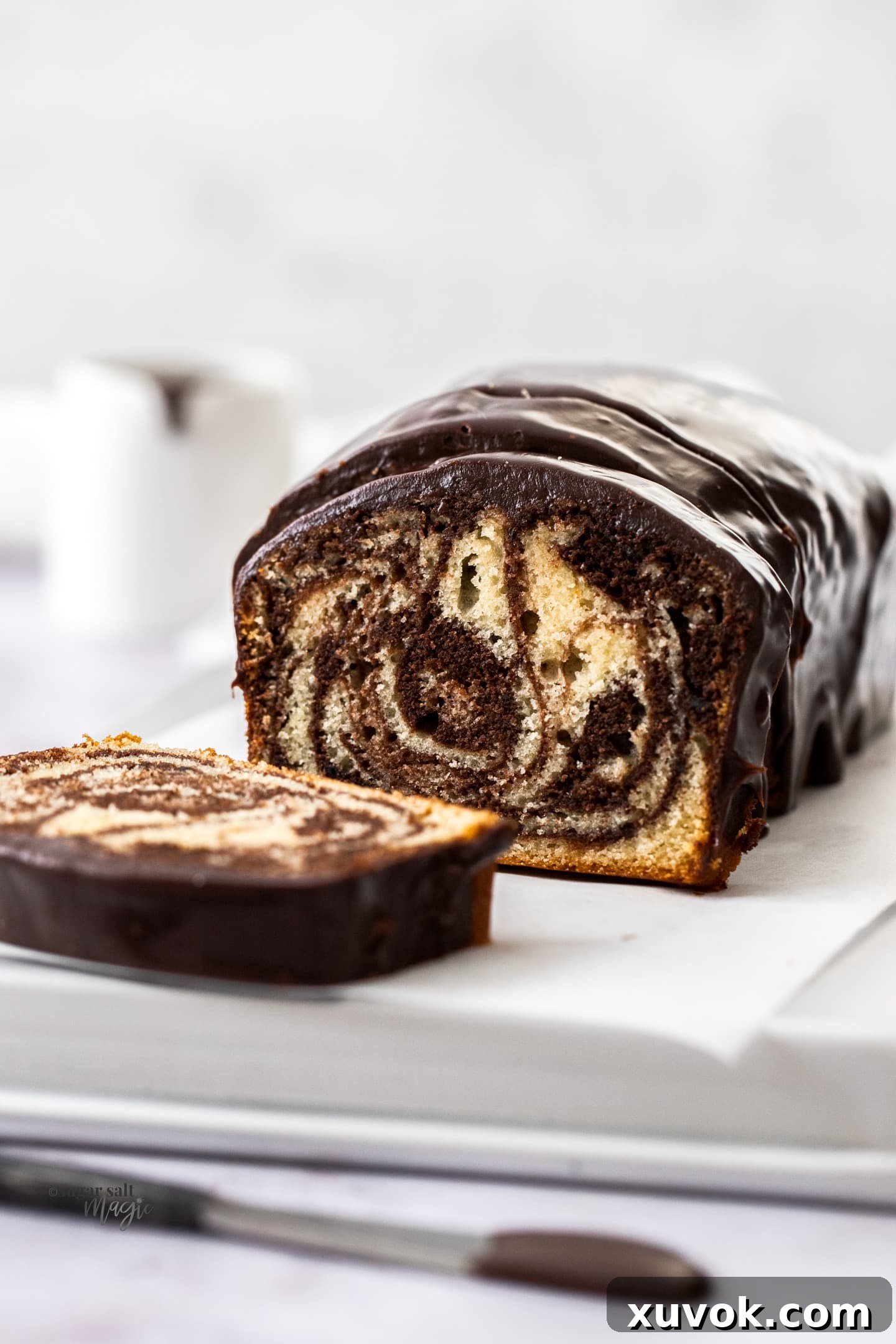 A marble loaf cake with slices cut away showing the inside.