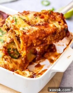 Steak enchiladas being lifted out of the pan.