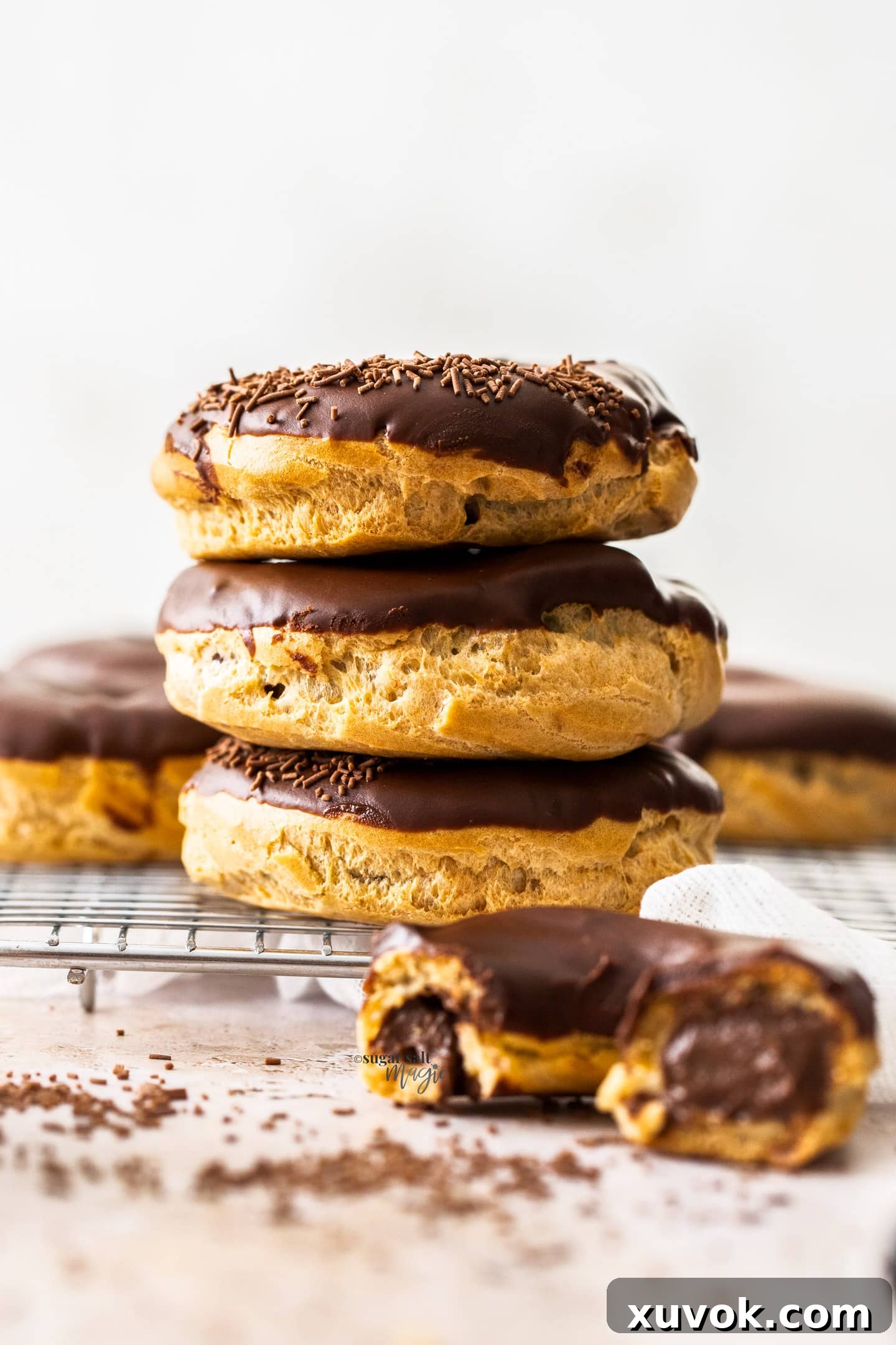 A perfectly stacked trio of chocolate chouxnuts, showcasing their decadent filling and glaze.