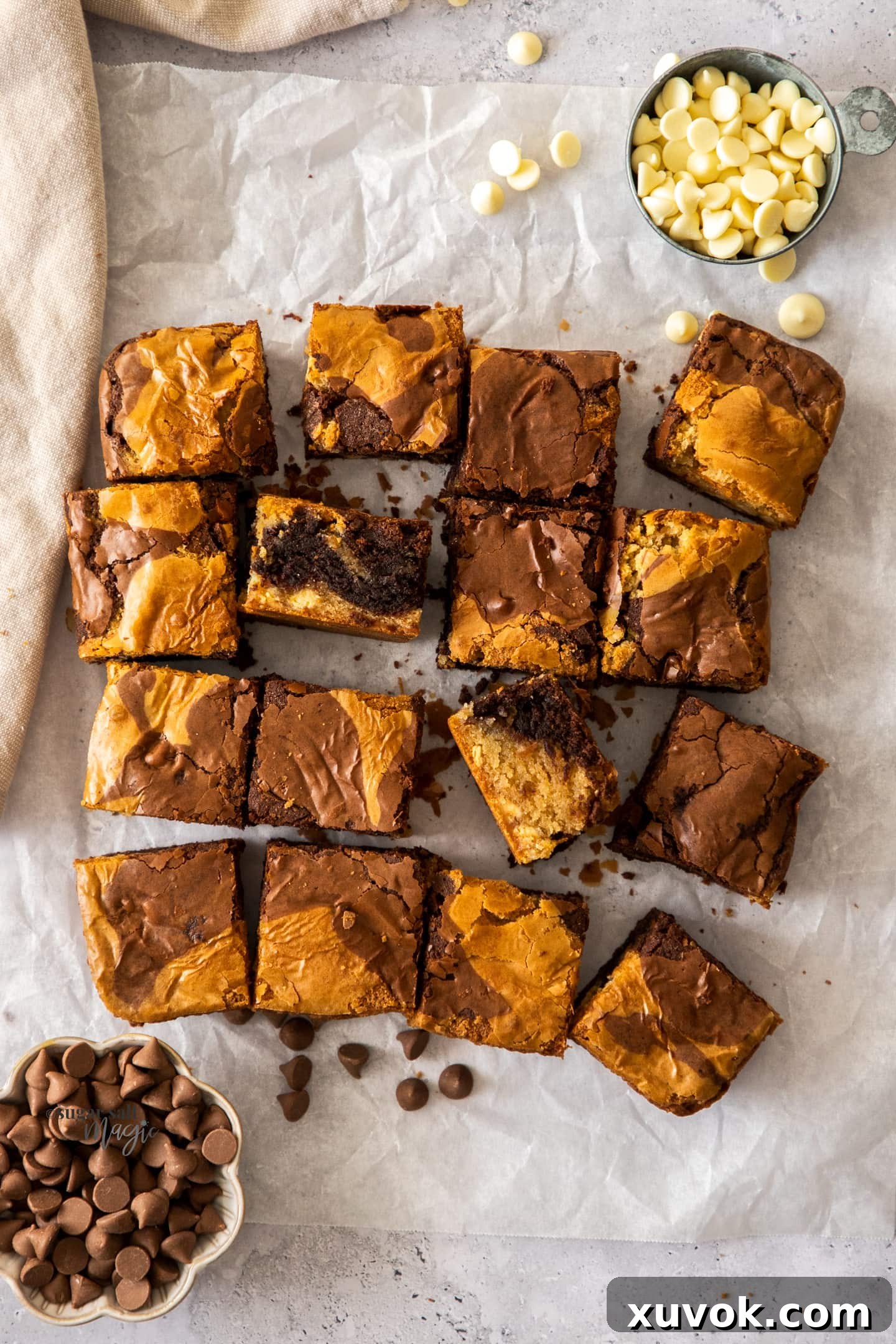 A batch of brownie blondies, cut into squares, surrounded by chocolate chips.