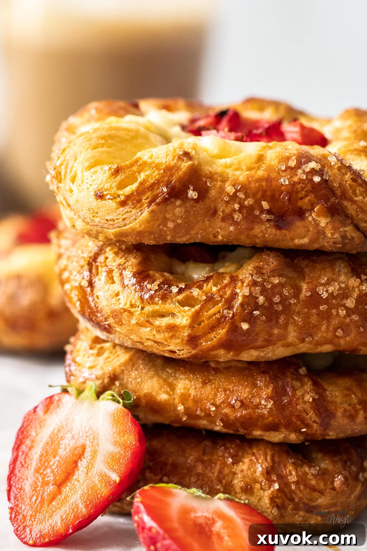 A closeup of a stack of strawberry Danish, showing the flaky pastry layers and creamy filling.