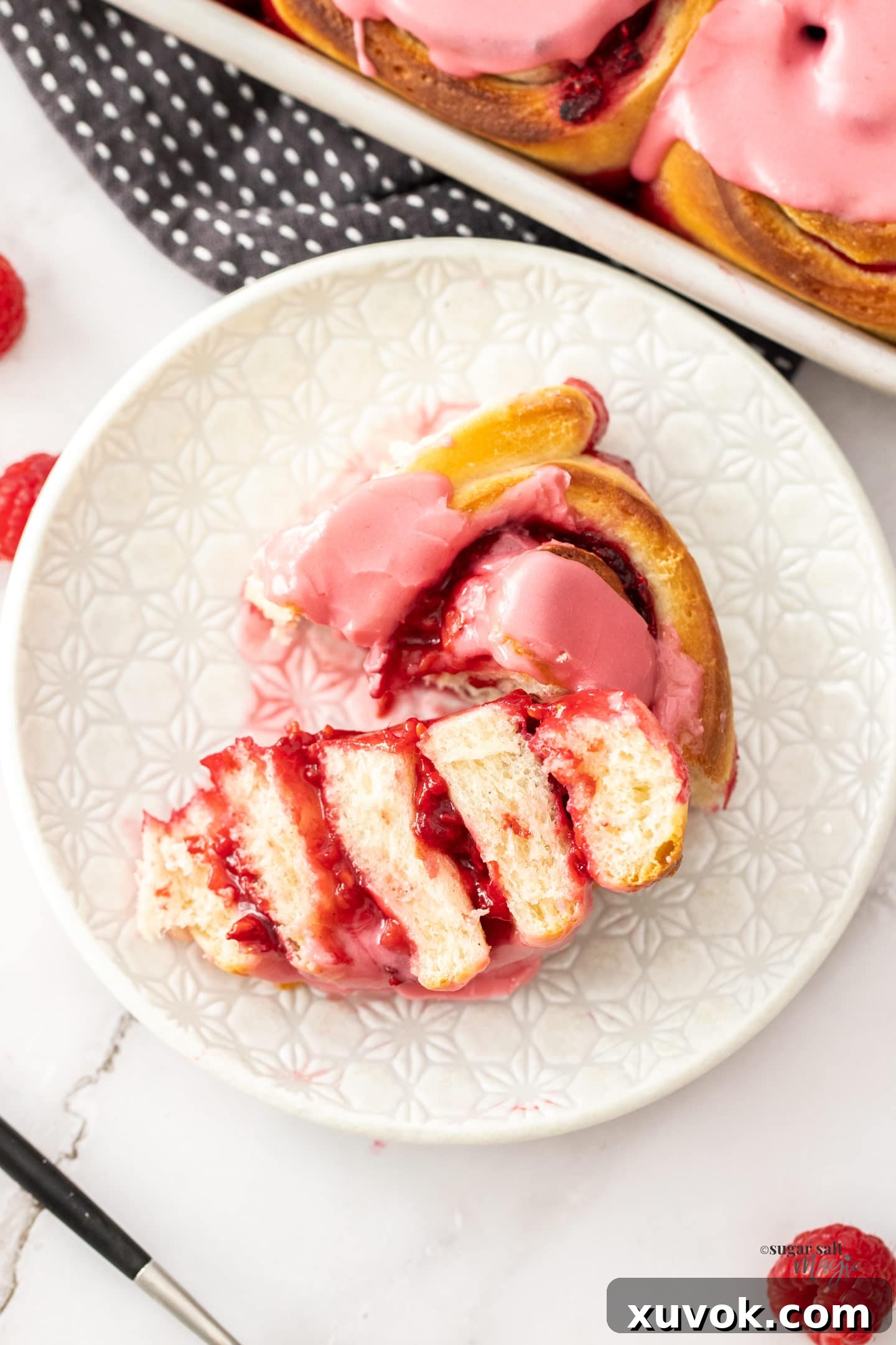 A raspberry sweet roll that's been cut open to show the inside.