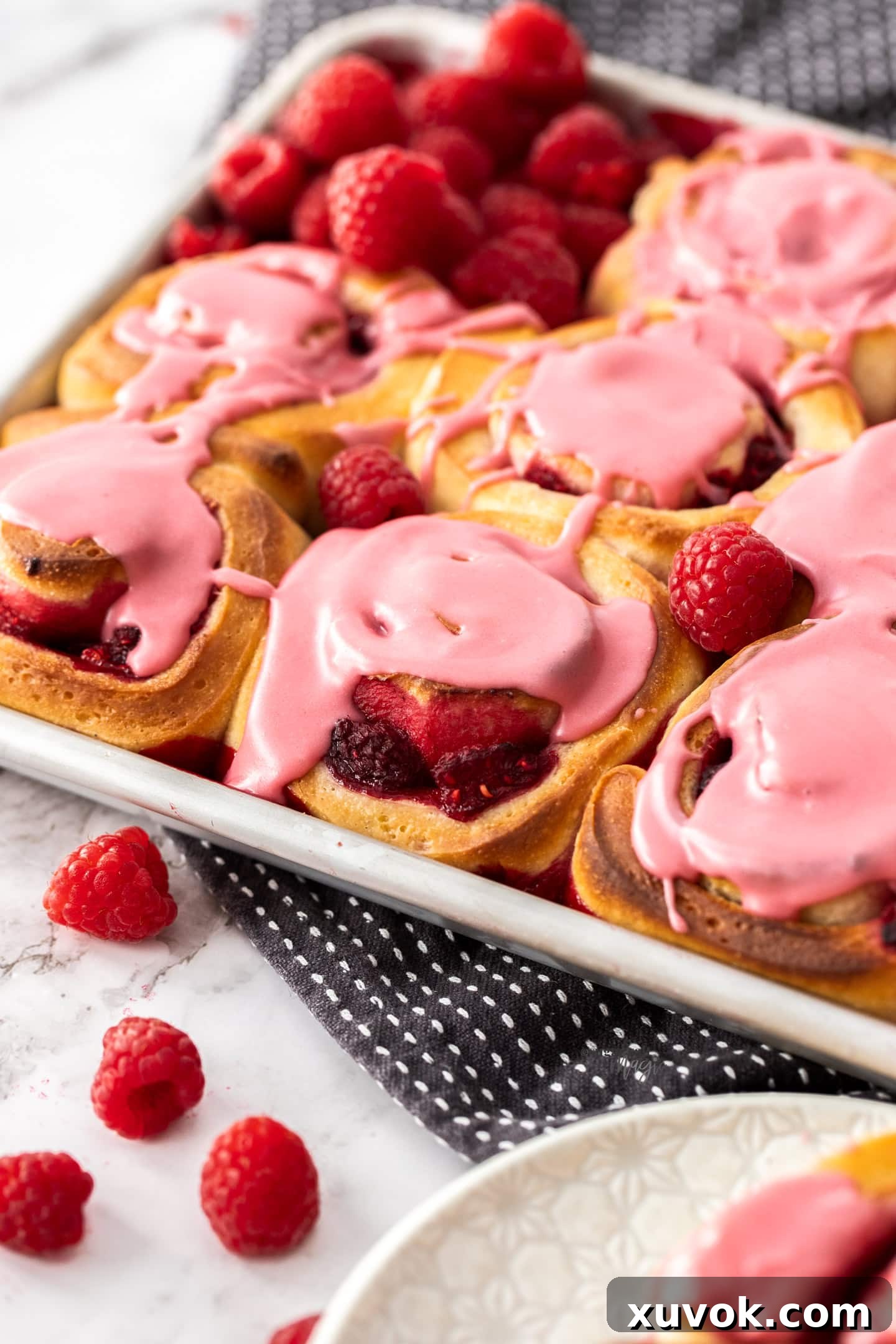 Closeup of raspberry sweet rolls in a baking tin.
