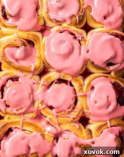 Close up of a tray of 12 raspberry rolls.