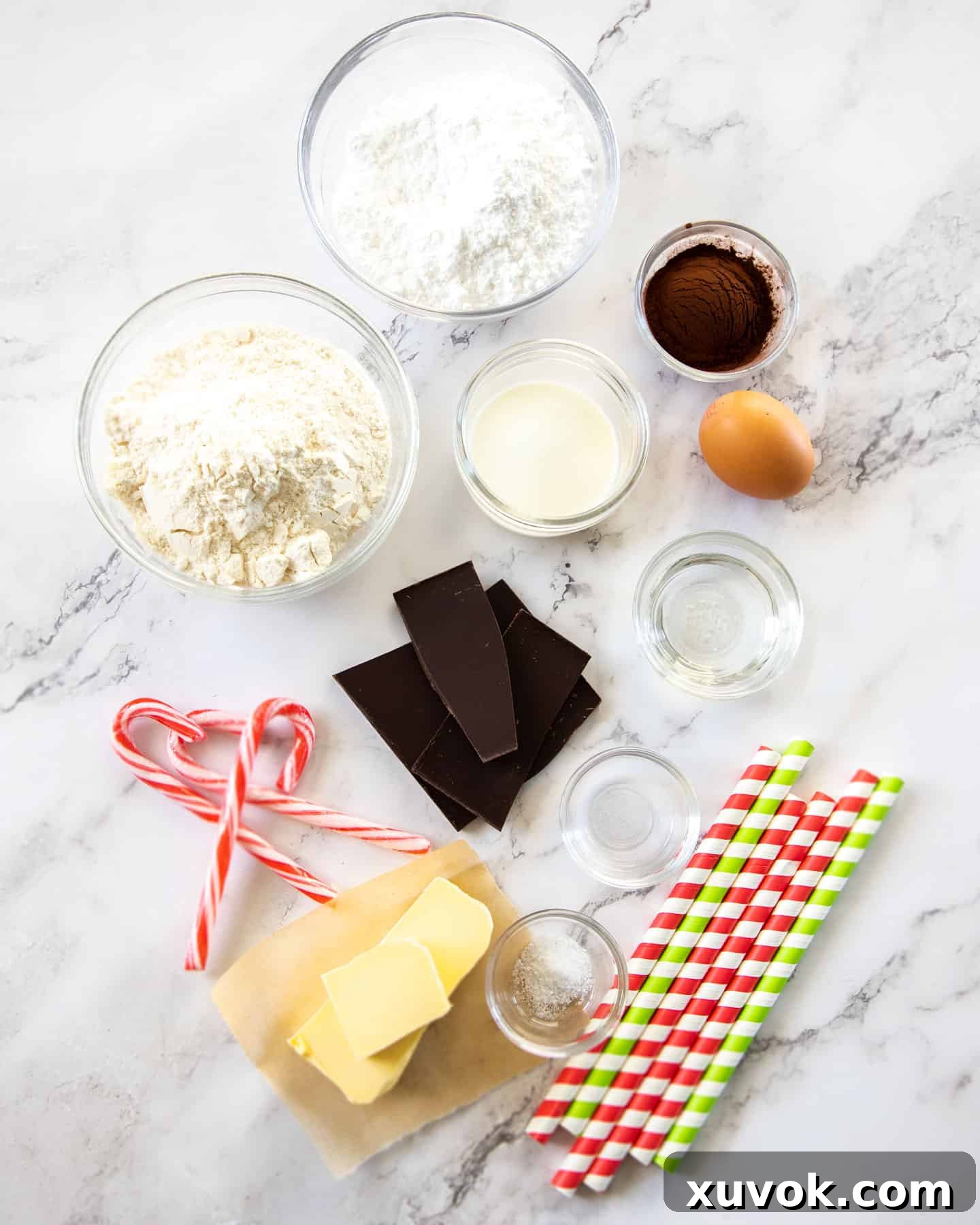 A beautifully arranged selection of ingredients for Peppermint chocolate roll cookies on a pristine marble surface, highlighting freshness and quality.