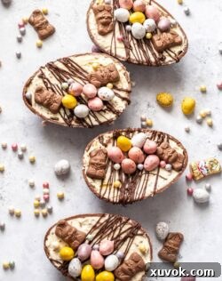 Top-down view of 4 Easter egg cheesecakes surrounded by festive decorations, ready for serving.
