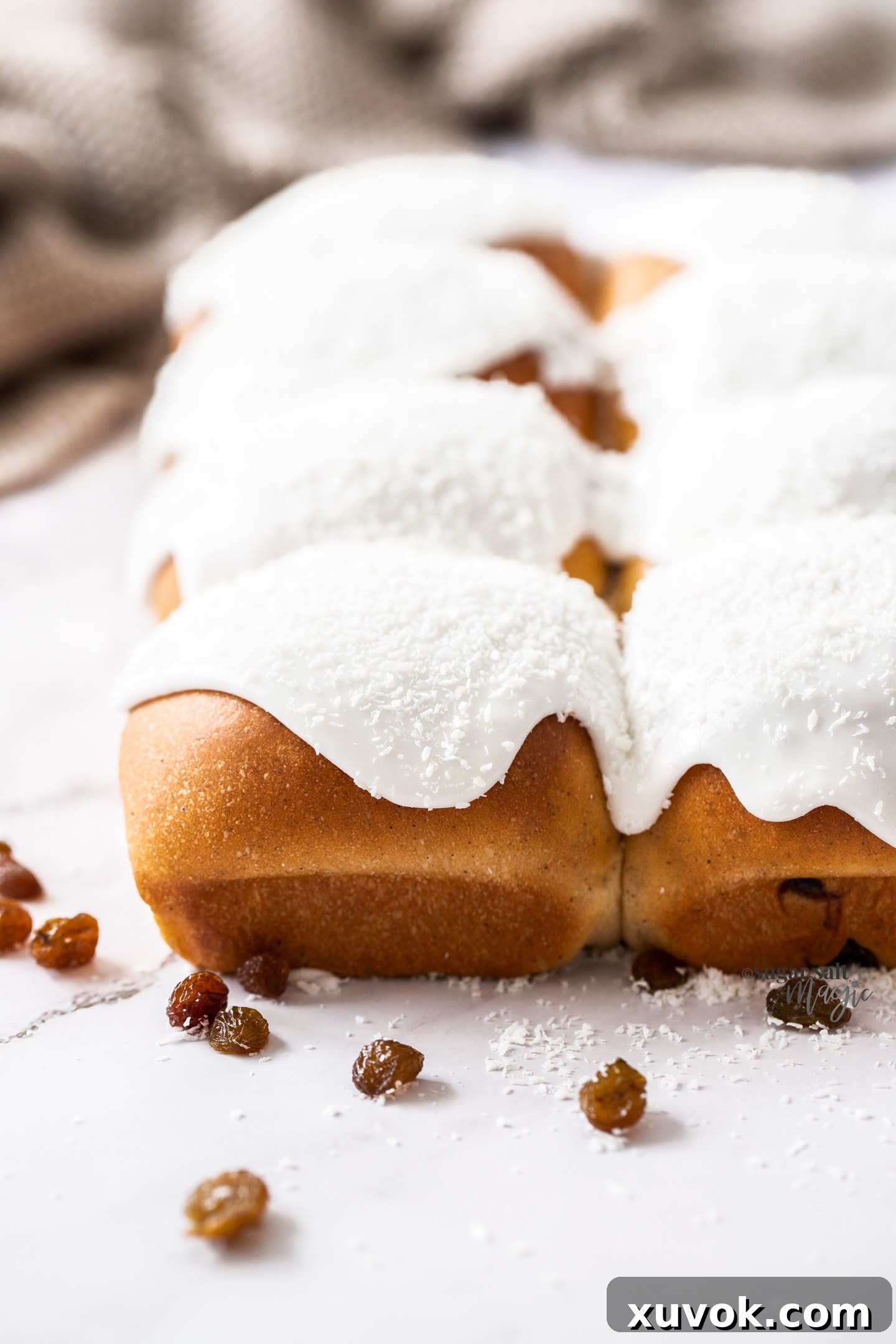 A batch of 8 sweet buns topped with white icing.