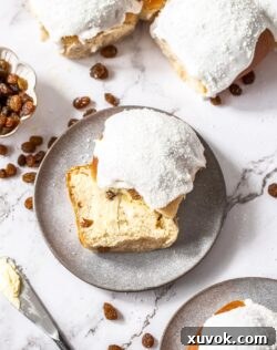 Top down view of white iced buns on a marble benchtop.