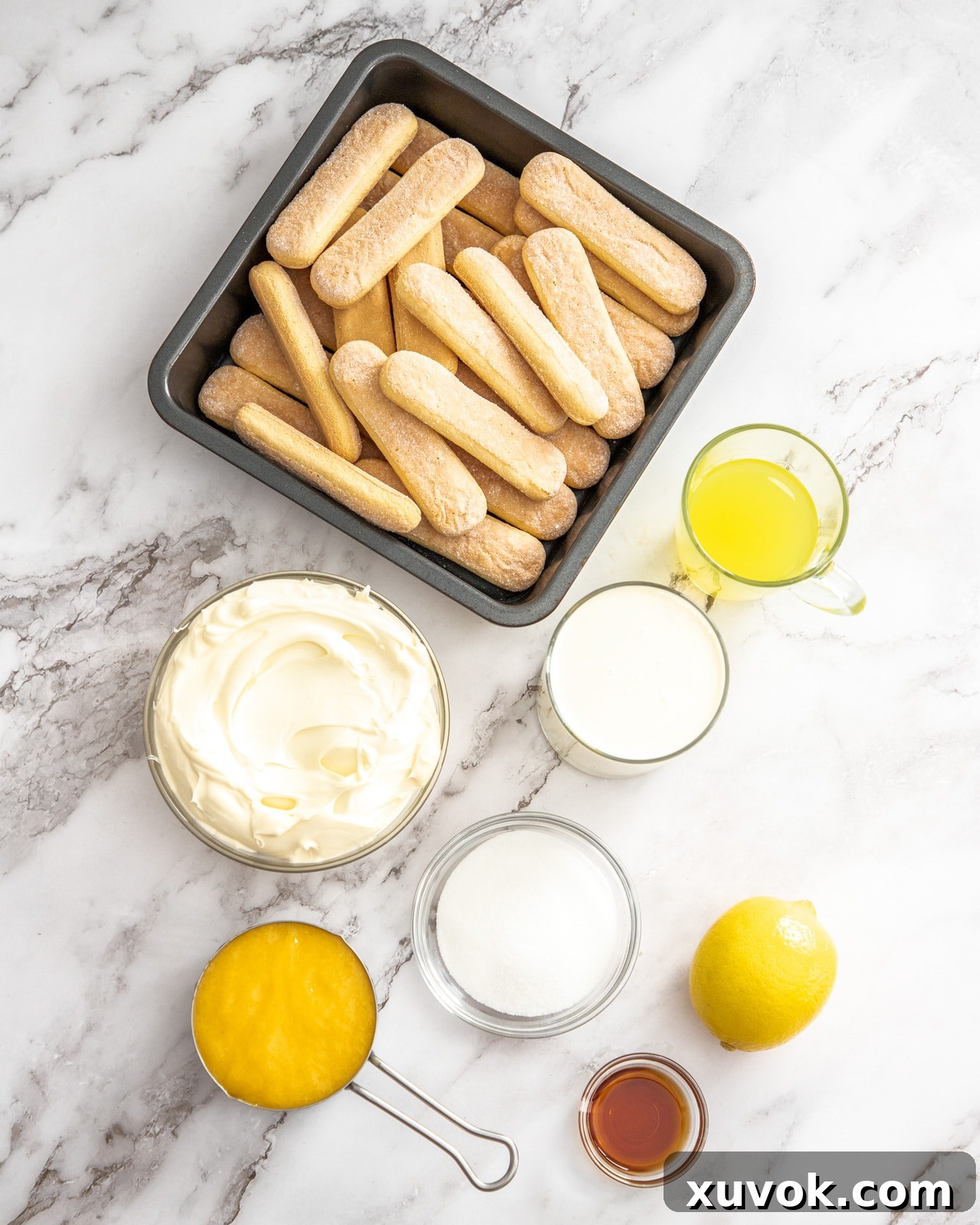 Ingredients for lemon tiramisu on a marble benchtop.