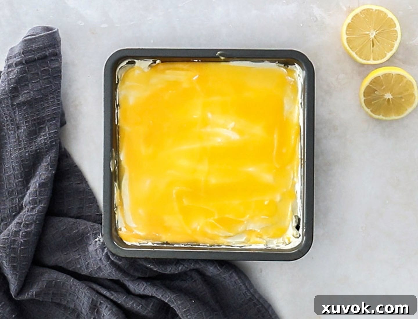 The ladyfingers topped with the cream mixture and lemon curd in the pan.