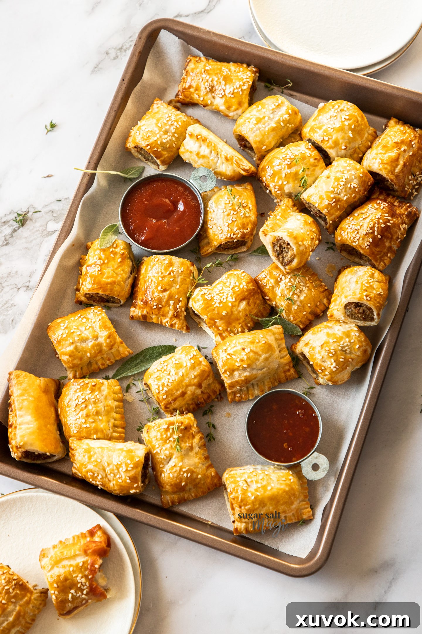 A big batch of golden-brown turkey sausage rolls on a baking tray, ready to be served as a delicious holiday appetizer or side dish.