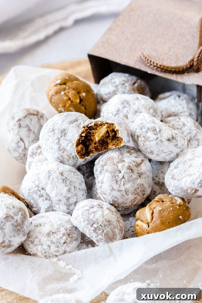 A charming pile of gingerbread flavored snowball cookies, elegantly tumbling out of a festive gift bag, ready for sharing.