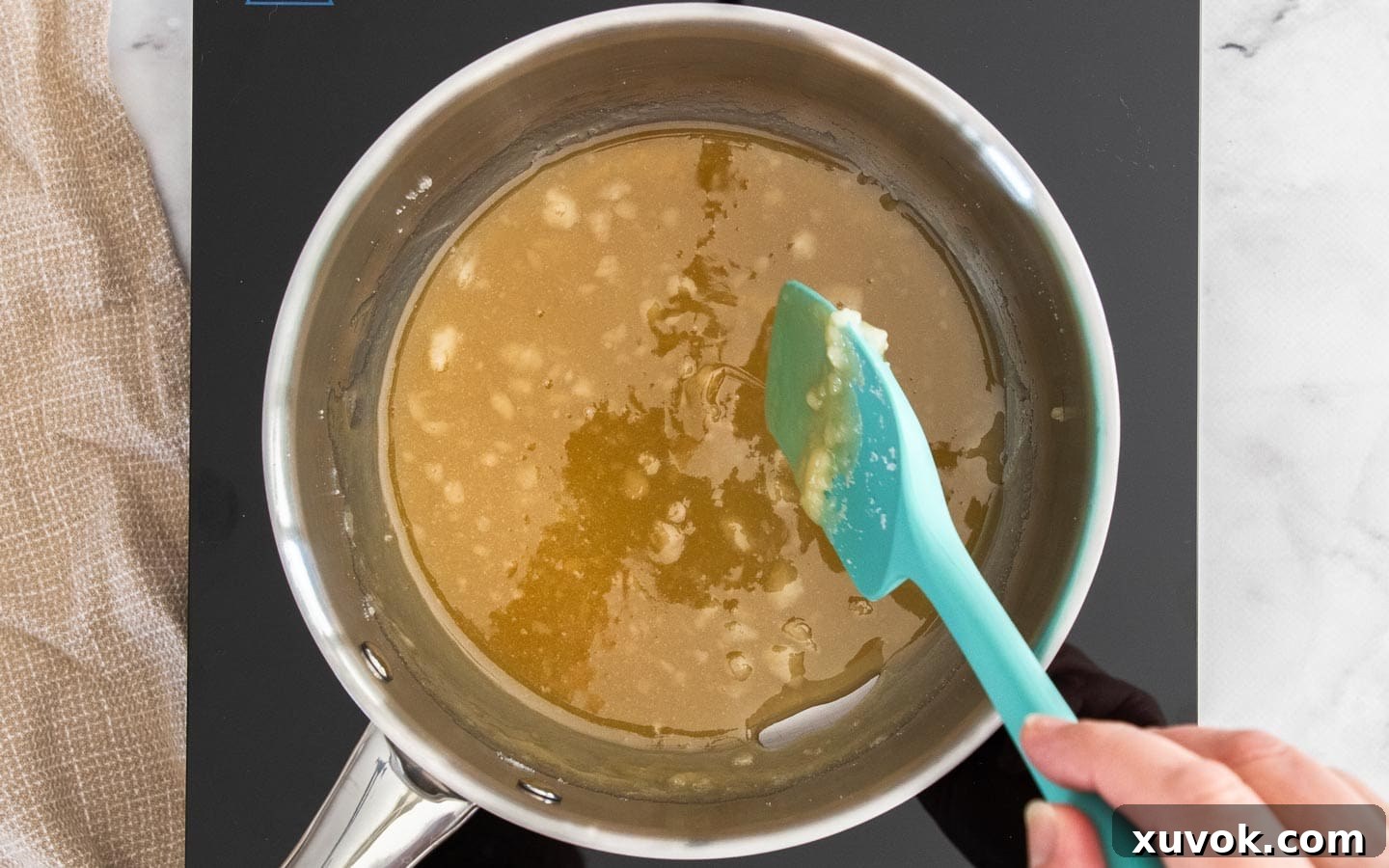 The sugar mostly dissolved into a smooth, golden caramel liquid, with only a few small clumps remaining.