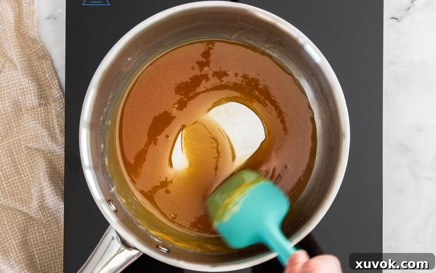 The smooth, uniformly amber caramel in a pan, perfectly melted and ready for the next ingredients.