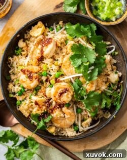 Top down view of a bowl of prawn fried rice topped with coriander.
